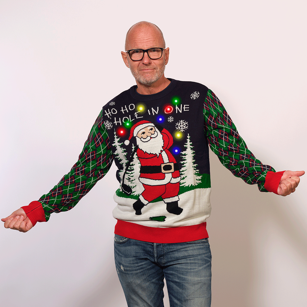 En mand poserer i en golfinspireret julesweater.